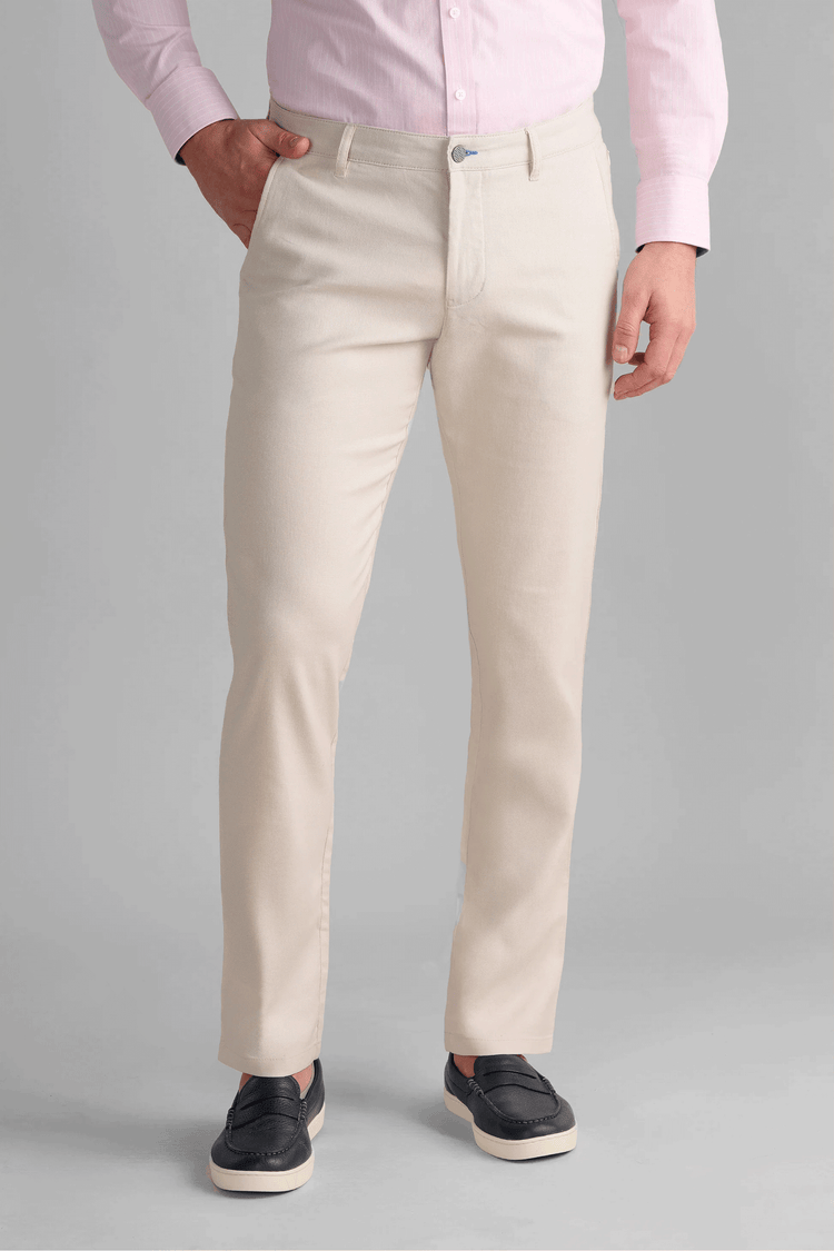 Twillory Performance Linen Pants in Bone: A non-iron, machine-washable off-white fabric blend (45% linen, 36% viscose, 19% polyester) with 4-way stretch and a shirt-gripping waistband. These moisture-wicking, hyper-breathable tailored trousers include hidden zippered travel pockets for professional summer styling.
