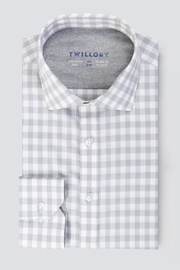 The Twillory Leader Gingham // Grey White is a neatly folded, long-sleeve button-up shirt with a light gray and white check pattern, classic collar, and white buttons, displayed against a plain light gray background.
