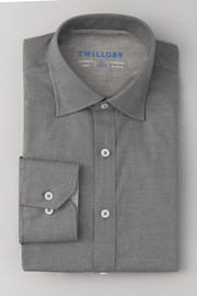 A neatly folded Twillory Leader Solid // Heather Grey long-sleeve performance shirt with 4-way stretch and white buttons is displayed on a light gray surface, showing the label and a single cuff with button on the left.