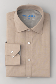 A neatly folded Twillory Leader Solid // Heather Sepia Performance Shirt with white buttons, pointed collar, and single cuff. The inside label reads TWILLORY in blue text. Displayed on a light gray surface.