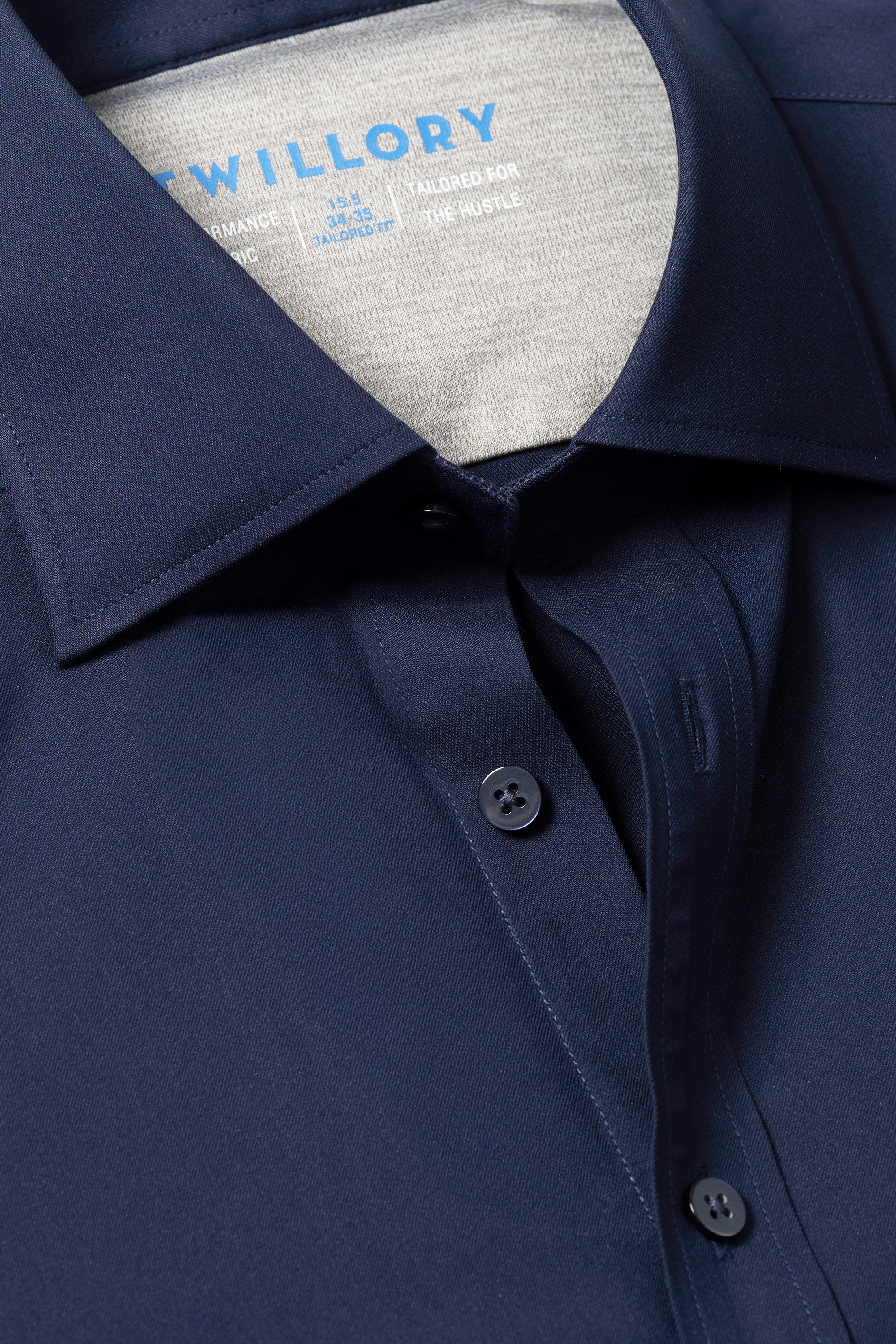 Close-up of Twillory’s Leader Solid // Navy shirt, highlighting the collar, two dark buttons, and partial inner label. The smooth, slightly shiny 4-way Stretch fabric showcases its modern non-iron comfort and style.