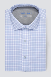 The Twillory Leader Plaid // Sky Blue is a neatly folded, long-sleeve shirt featuring a light blue and white check pattern, 4-way stretch, pointed collar, matching blue buttons, Twillory branding inside the collar, and crisp fabric.