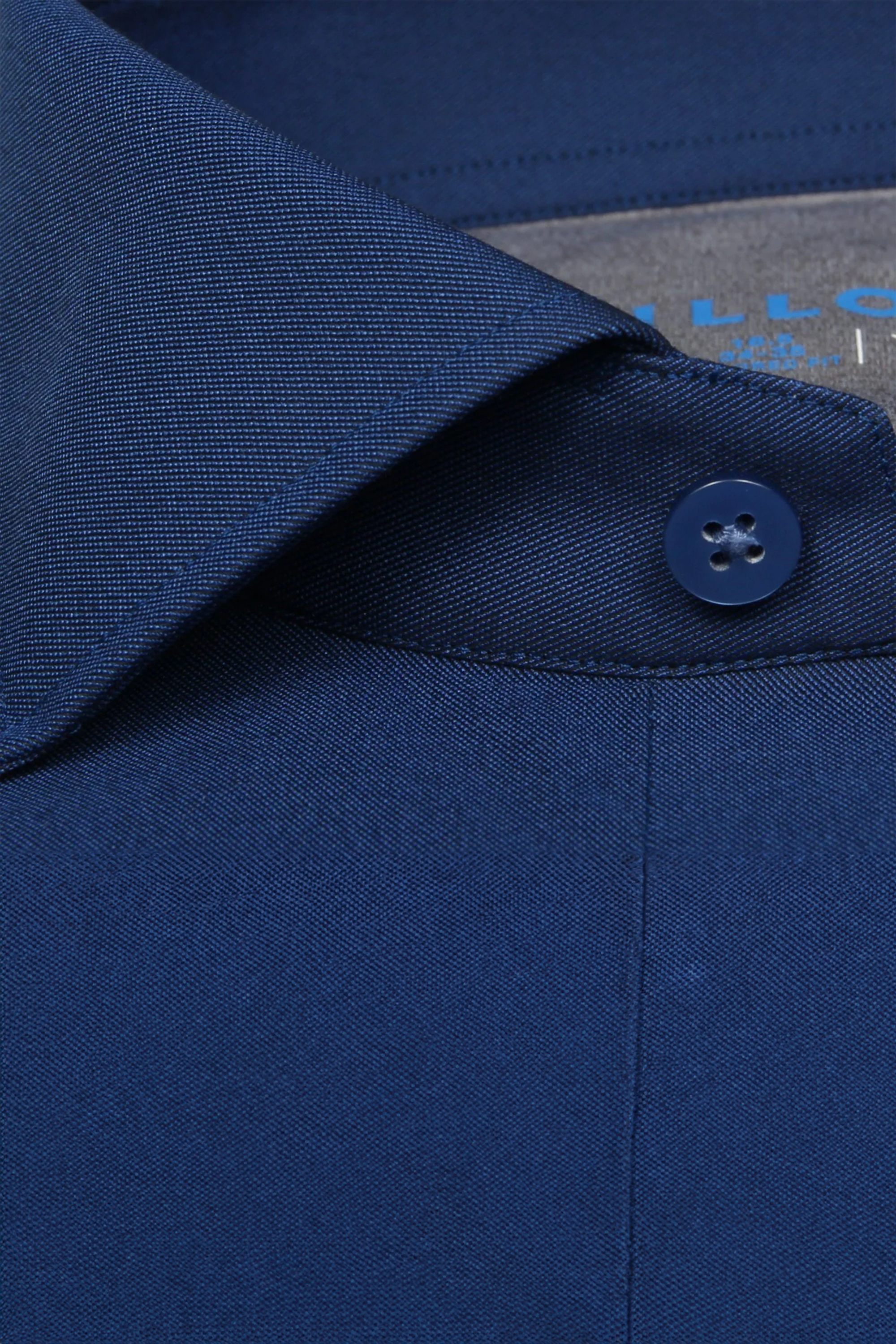 A close-up of a button on the Twillory Leader Solid // Royal Blue performance shirt, highlighting its moisture-wicking fabric.