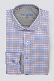A neatly folded Twillory Leader Windowpane // Orange Blue long-sleeve button-up shirt features an orange and blue plaid pattern. The inside collar displays the Twillory brand in blue text. Shown on a light gray background.