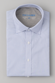 A neatly folded Twillory Leader Check // Pink Blue Hatch Performance Shirt features a pink and blue micro-check pattern, white buttons, 4-way stretch fabric, and a stiff collar. The TWILLORY label is inside. Displayed on a plain gray background.