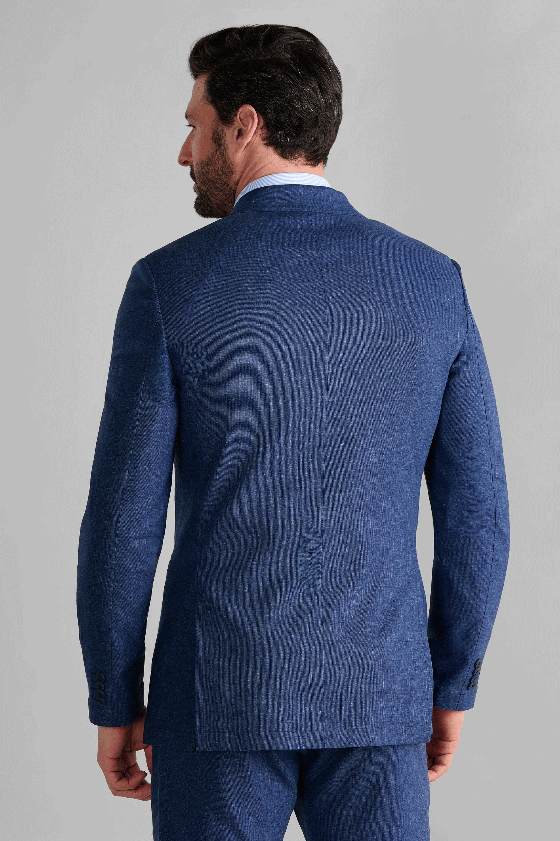 Rear view of the Twillory Blue Performance Linen Jacket highlighting the double-vented back and tailored fit with a mild waist taper. The non-iron performance material maintains its structure without creasing, ideal for professional environments and business travel.