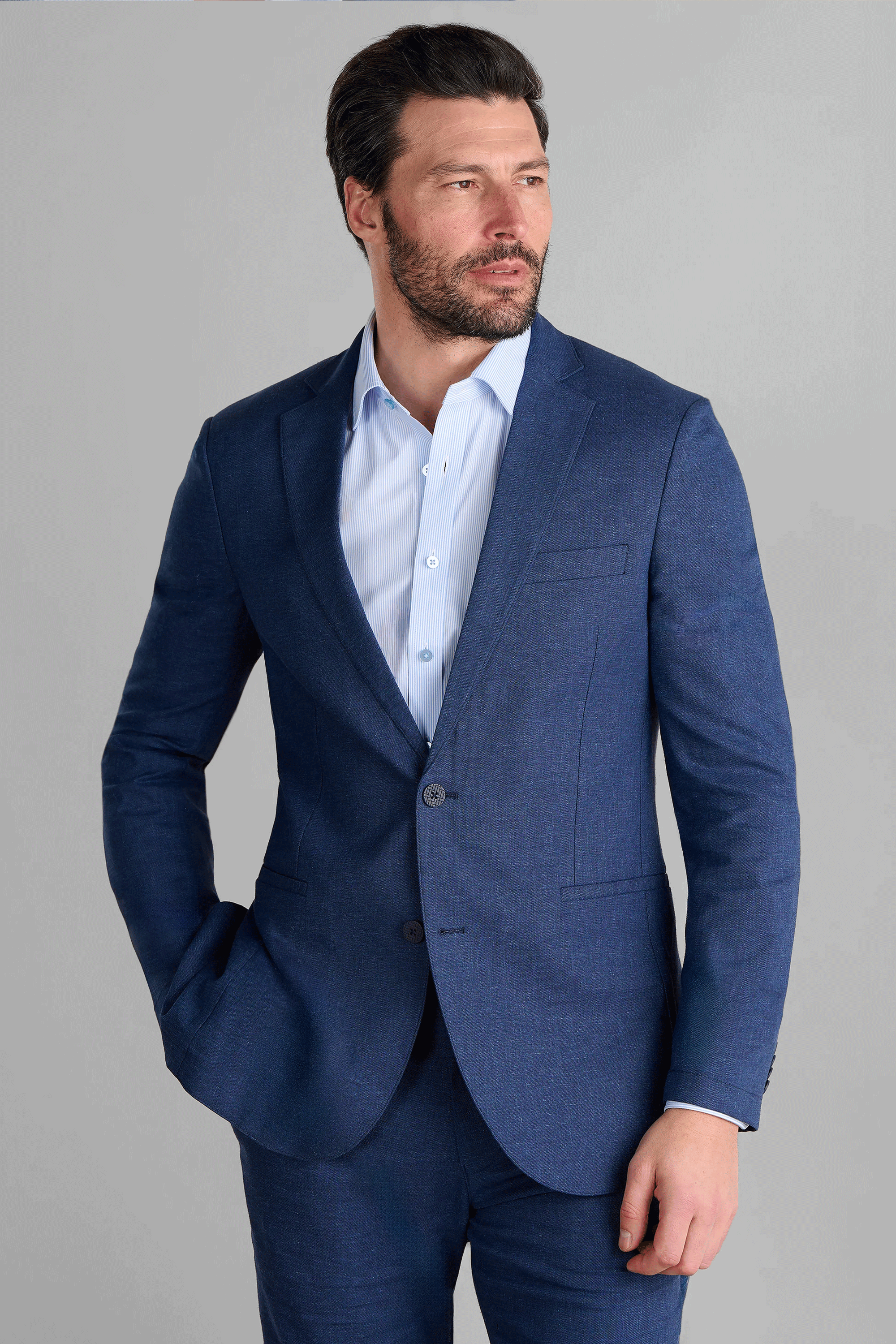 Twillory Performance Linen Blazer in Blue: A tailored, 2-button jacket made from a machine-washable fabric blend ($45\%$ linen, $36\%$ viscose, $19\%$ polyester). This hyper-breathable blazer features dynamic 4-way stretch, proprietary 3D shoulder pads, and a non-iron finish for a crisp, professional look.