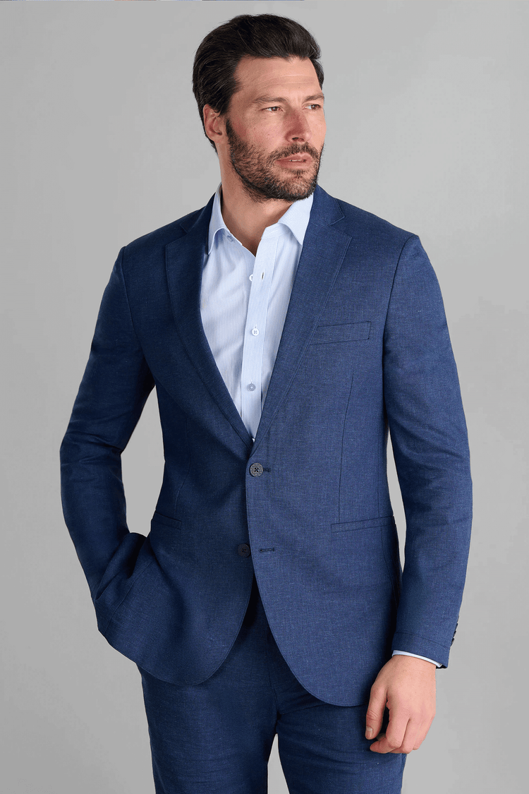 Twillory Performance Linen Blazer in Blue: A tailored, 2-button jacket made from a machine-washable fabric blend ($45\%$ linen, $36\%$ viscose, $19\%$ polyester). This hyper-breathable blazer features dynamic 4-way stretch, proprietary 3D shoulder pads, and a non-iron finish for a crisp, professional look.