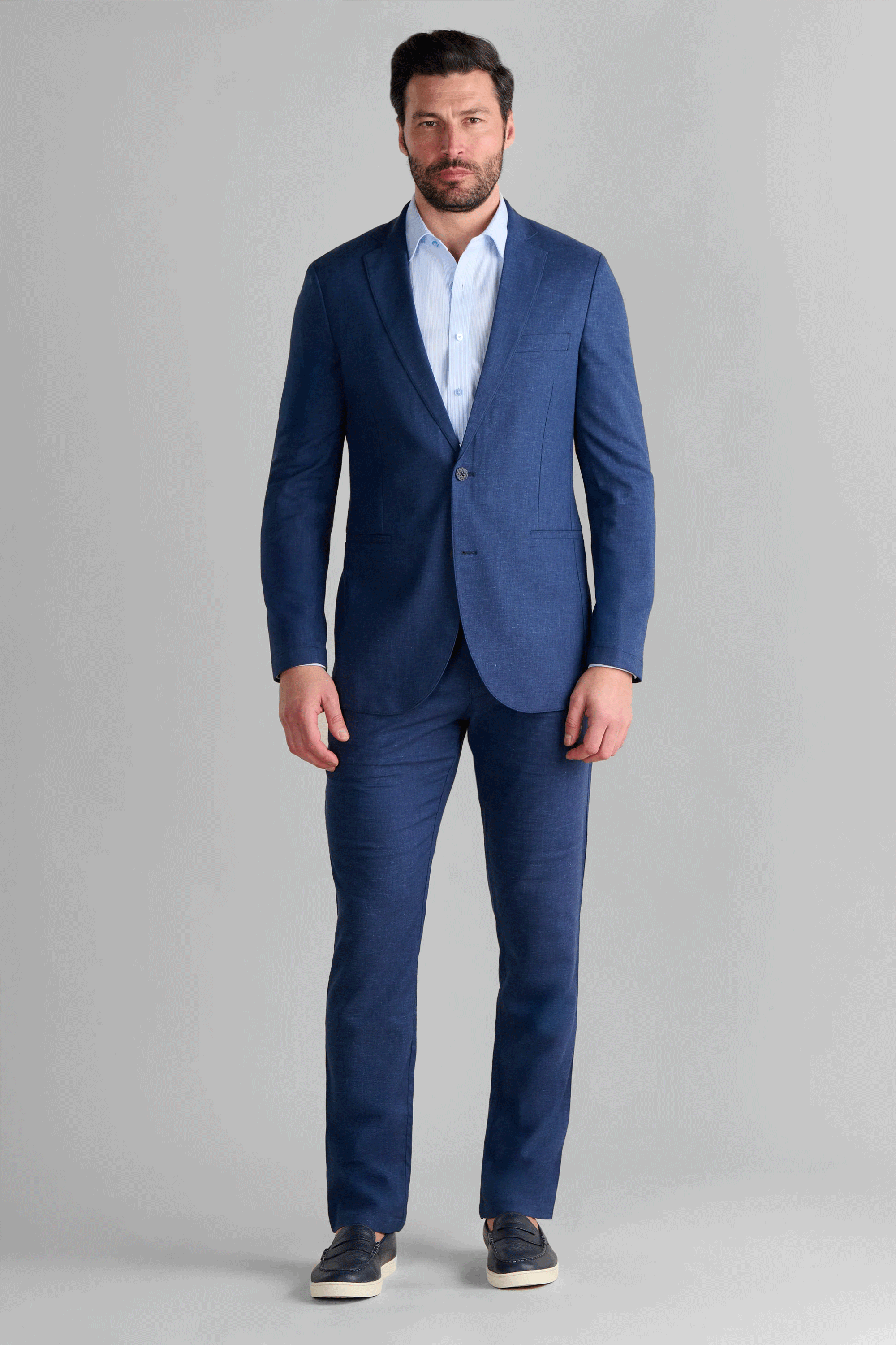 Man wearing the Twillory Performance Linen Suit in Blue, featuring a tailored-fit blazer and matching trousers. This lightweight, wrinkle-resistant suit is designed for summer weddings and travel, combining classic linen texture with modern performance mobility.
