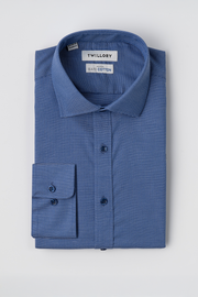 A neatly folded, long-sleeve Twilight Pin Dot shirt by Twillory with a subtle blue micro-pattern. Non-iron SafeCotton fabric, classic collar, buttoned cuffs, and Twillory and SafeCotton labels at the collar on a white background.