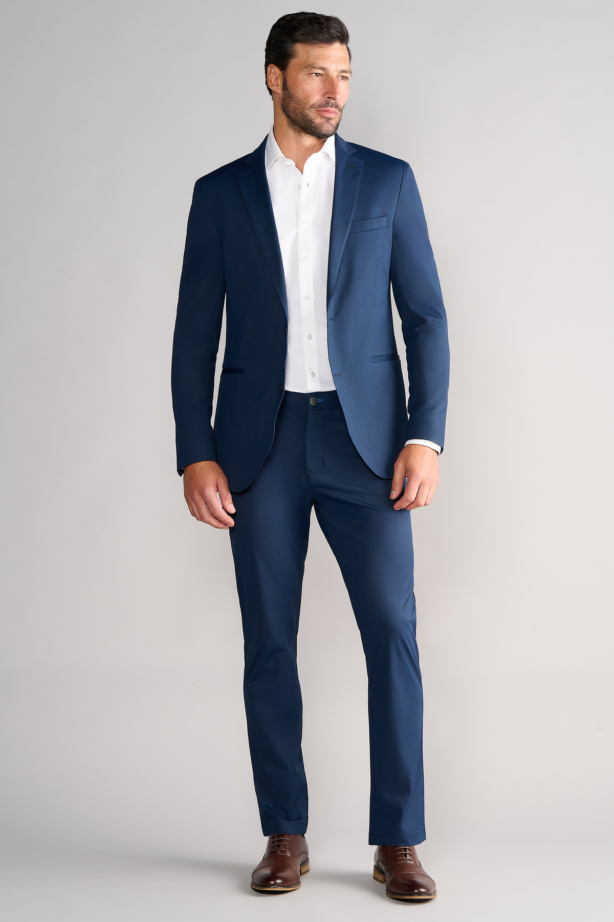 Full-length view of model wearing Performance Blazer – Navy Houndstooth looking left for overall fit.