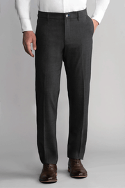 A man stands against a plain gray background wearing Twillory Hybrid Wool Pants in Grey Heather. His left hand is in his pocket, right arm by his side, and the image focuses on his lower torso and legs.