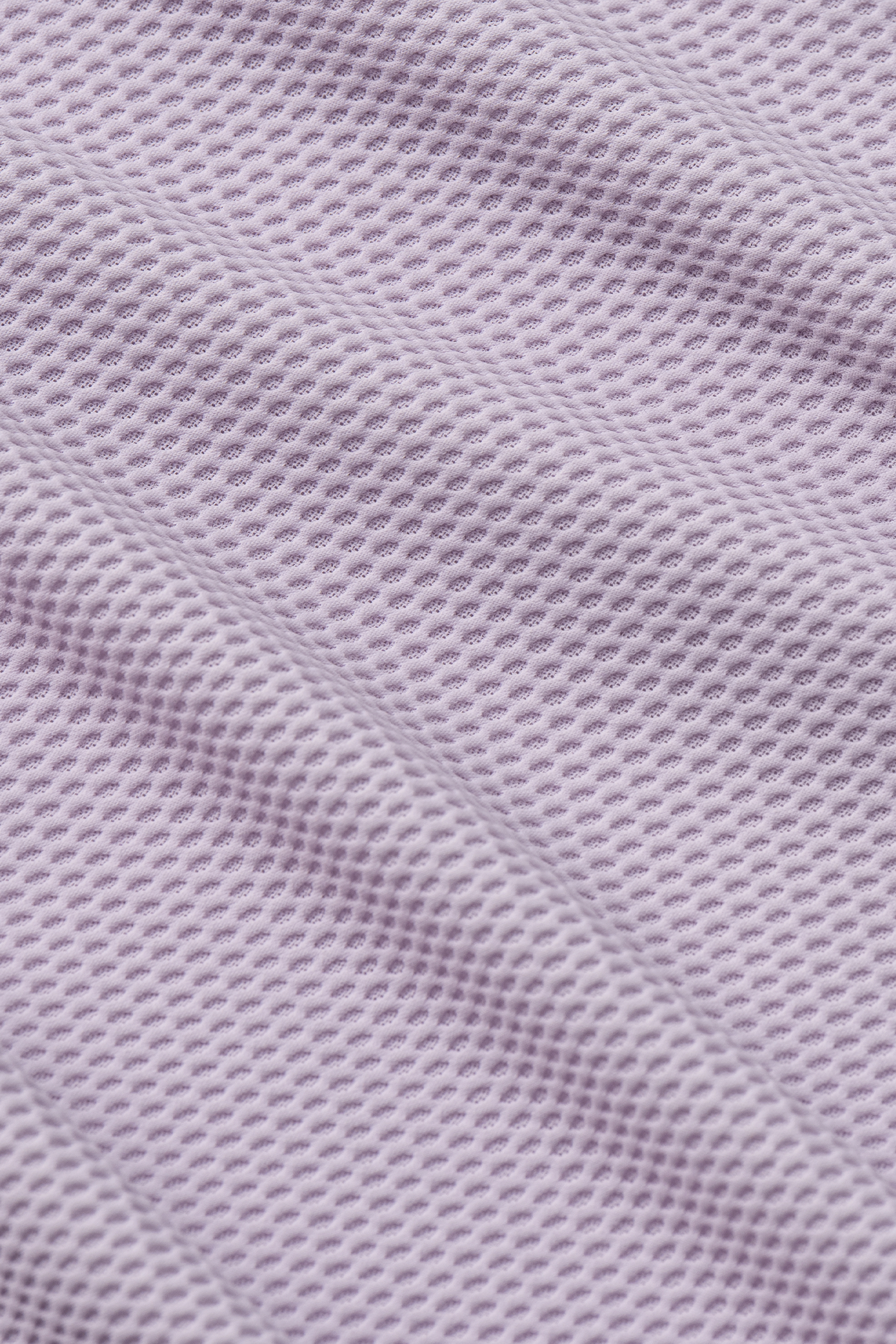 Close-up of Twillory's AIR Resort Shirt Solid in Lilac, featuring textured, light purple cooling fabric with a honeycomb pattern and raised oval holes for breathability—flexible, soft, and machine washable for resort-ready comfort.