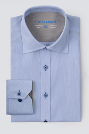 The Twillory Leader Stripe // Micro Blue shirt is neatly folded, featuring light blue fabric with thin white stripes, blue buttons, a contrast inner collar, 4-way stretch material, one cuff shown, and the brand name inside the collar.