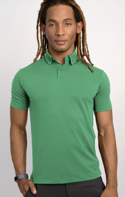 A person with long, light brown dreadlocks models the Twillory Short Sleeve Polo Solid // Mint, paired with black pants and a black wristband, standing forward-facing with a neutral expression against a plain light background.