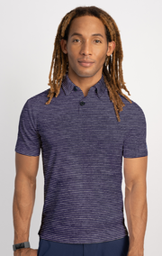 A person with long, light brown dreadlocks wears the Twillory Short Sleeve Polo Stripe in Navy Grey, standing against a plain light gray background with a neutral expression and a dark wristband on their left wrist.