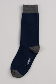 A single Twillory Navy Solid sock with gray heel, toe, and cuff lies flat on a light background. "Twillory" is printed in white near the toe, making it a favorite for everyday comfort.