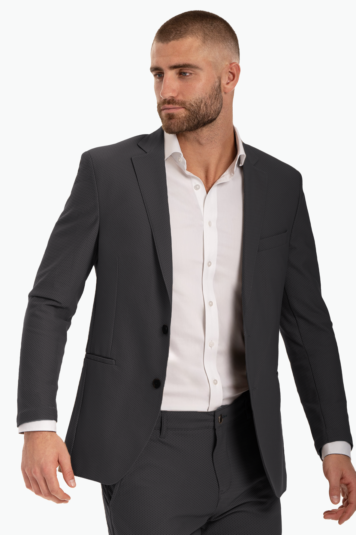 Man wearing a stylish dark suit with a white dress shirt, posing confidently against a plain background.